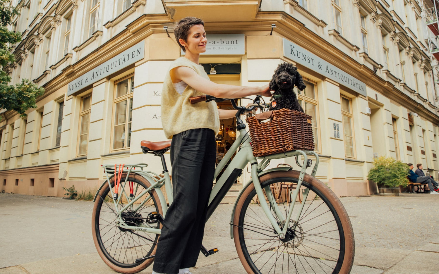 Woman and dog in the city with electric bike Jordaan plus in green Woman and dog in the city with electric bike Jordaan plus in green