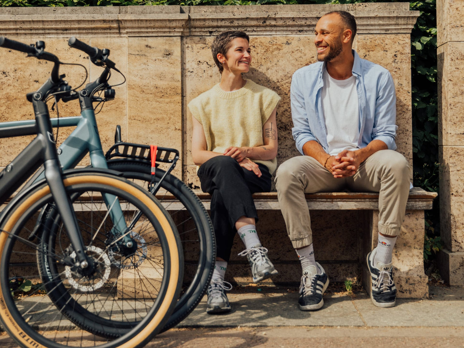 Friends on a bench next to Amsterdam electric ebikes