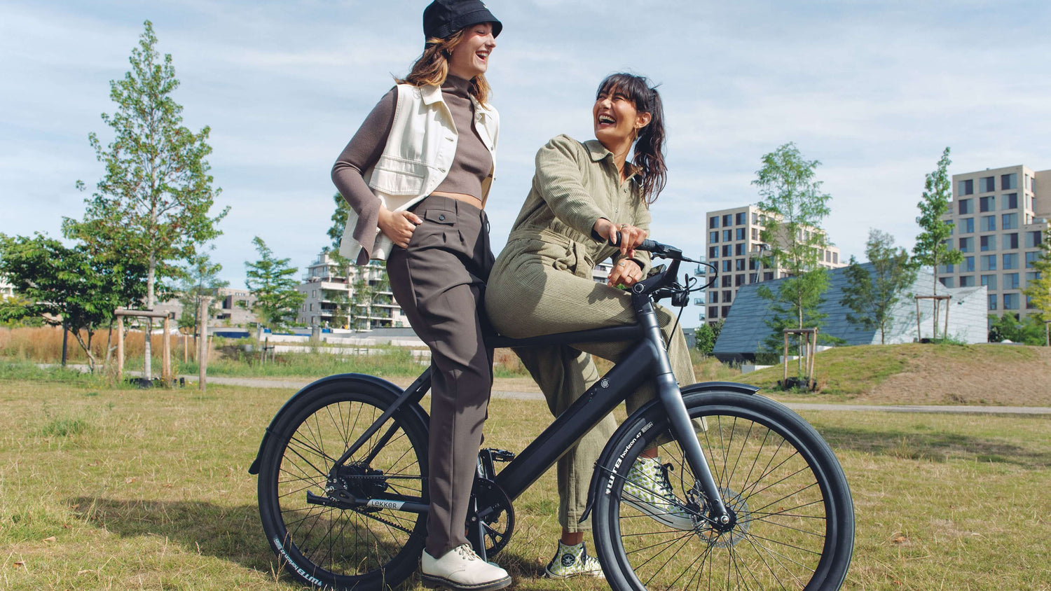 2 friends on Amsterdam electric bike smiling