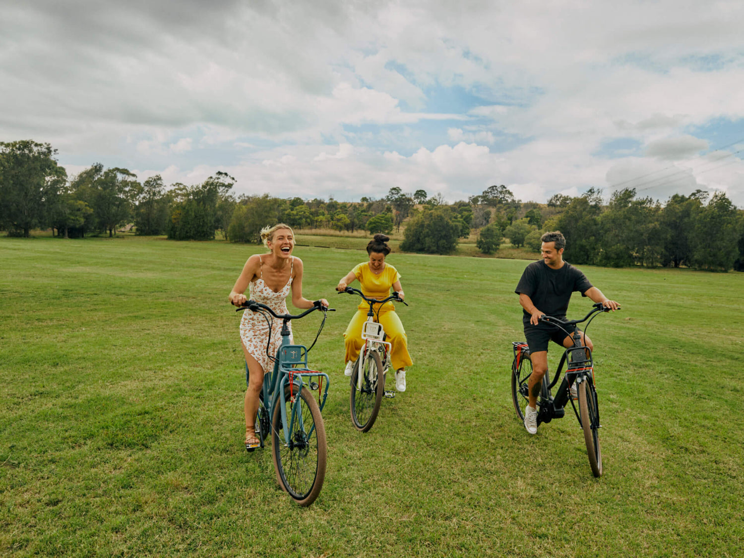 Happy friends cycling in park with Jordaan GT ebikes