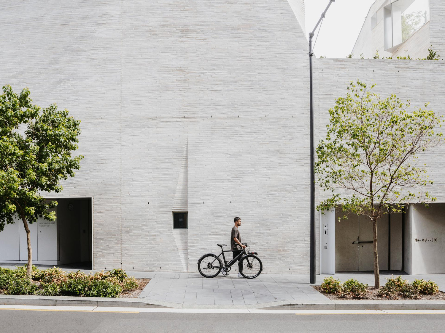 Man with bike in hand in city