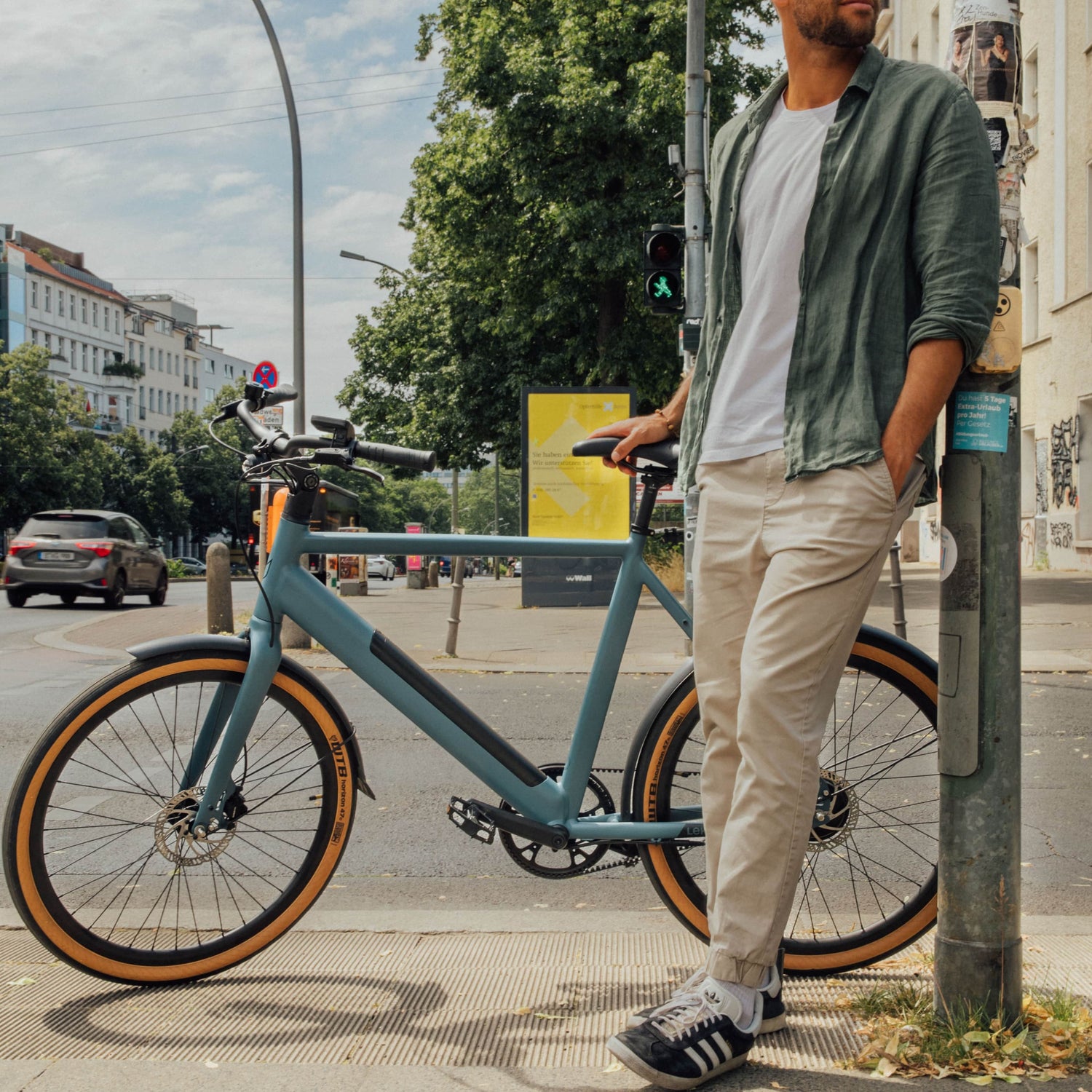 Guy standing next to his Amsterdam plus ebike concrete blue